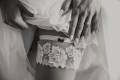 bride-putting-a-wedding-garter-on-her-leg-2022-02-02-03-48-07-utc (1)